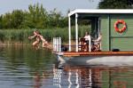 Kinder springen vom Bungalowboot ins Wasser
